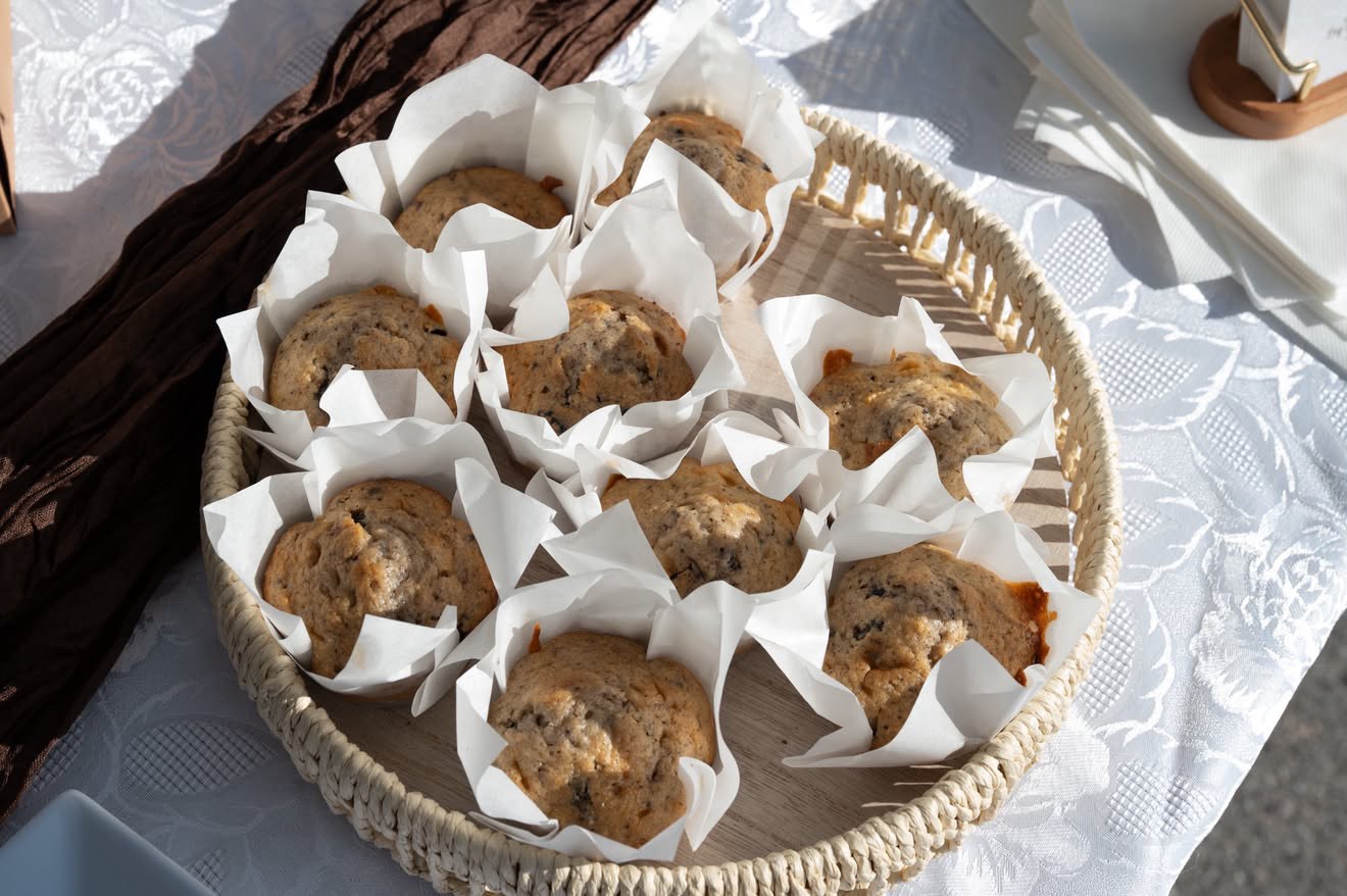 Homemade muffins in a wicker basket on a lace tablecloth