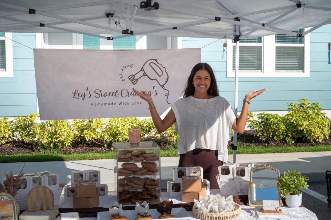 Ley smiling behind her Ley’s Sweet Cravings dessert table